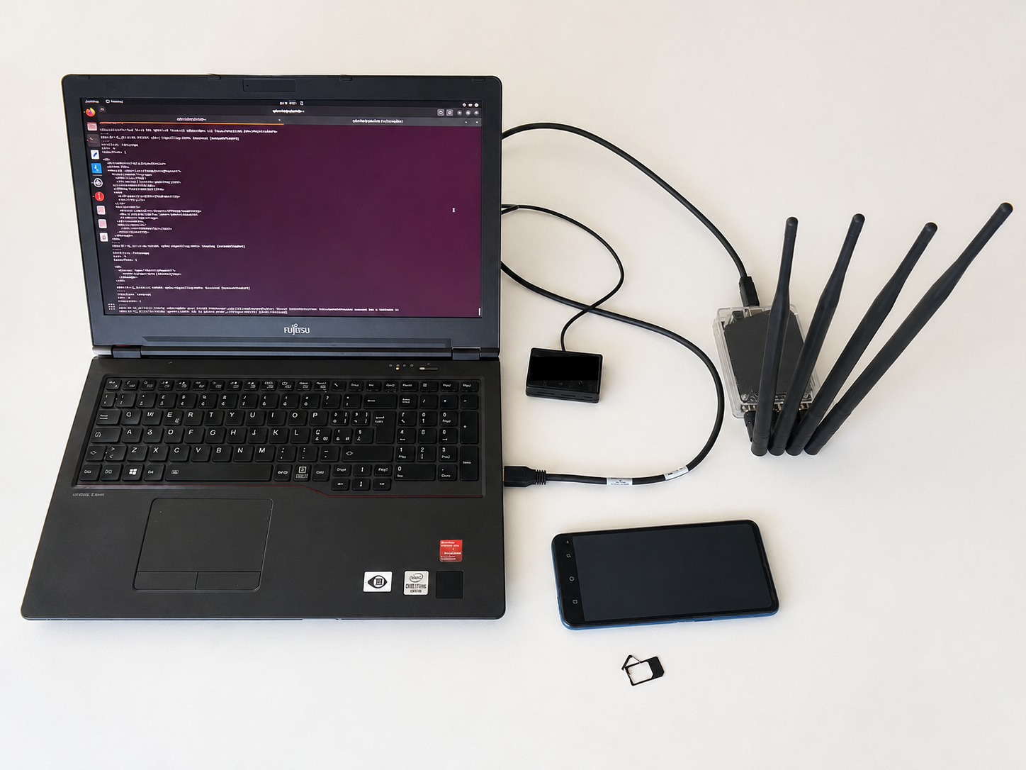 lab setup with the phone, Osmocom SIM, reader and YateBTS/bladeRF host